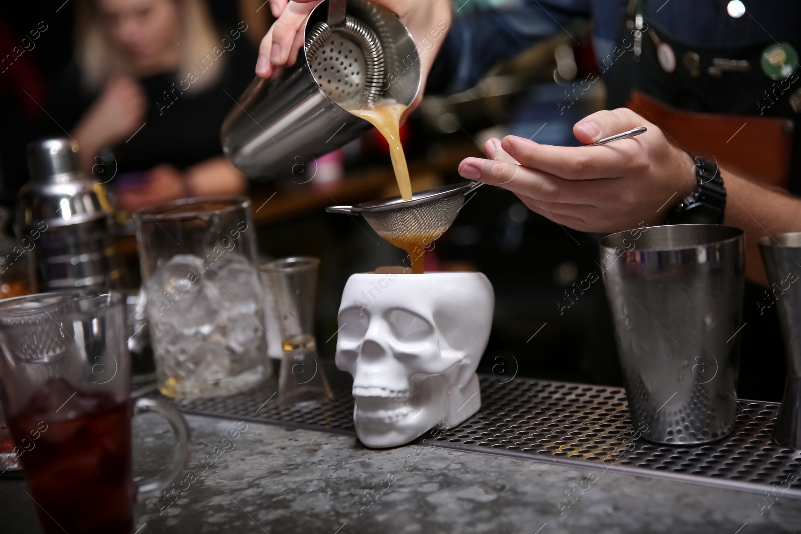 Photo of Bartender pouring tasty cocktail at counter in nightclub, closeup