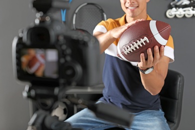 Photo of Sport blogger with ball recording video on camera at home