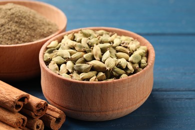 Photo of Cardamom and other spices on blue wooden table, closeup