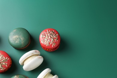 Photo of Beautifully decorated Christmas macarons on green background, above view. Space for text