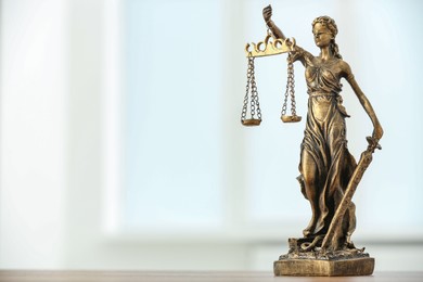 Figure of Lady Justice and gavel on table against light background, space for text. Symbol of fair treatment under law