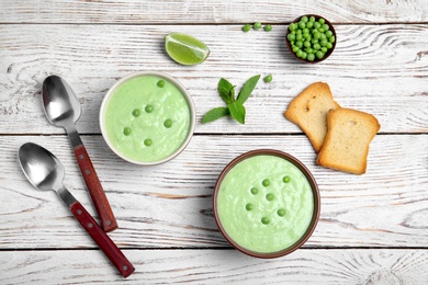 Photo of Flat lay composition with green pea soup on wooden background