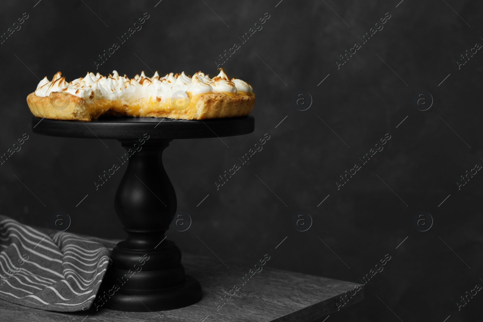 Photo of Stand with delicious lemon meringue pie on grey table, space for text