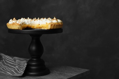 Photo of Stand with delicious lemon meringue pie on grey table, space for text