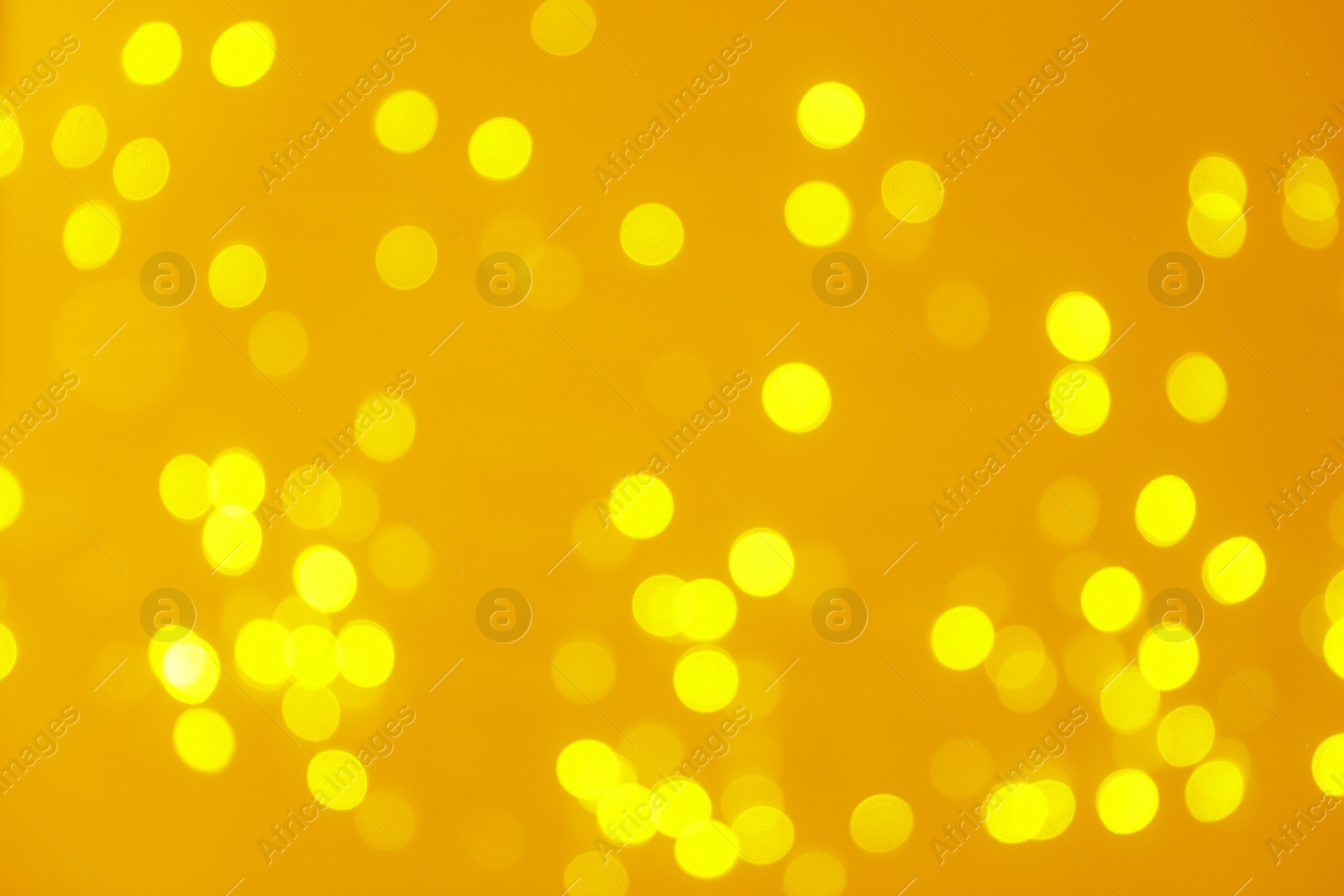 Photo of Blurred view of shiny gold lights. Bokeh effect