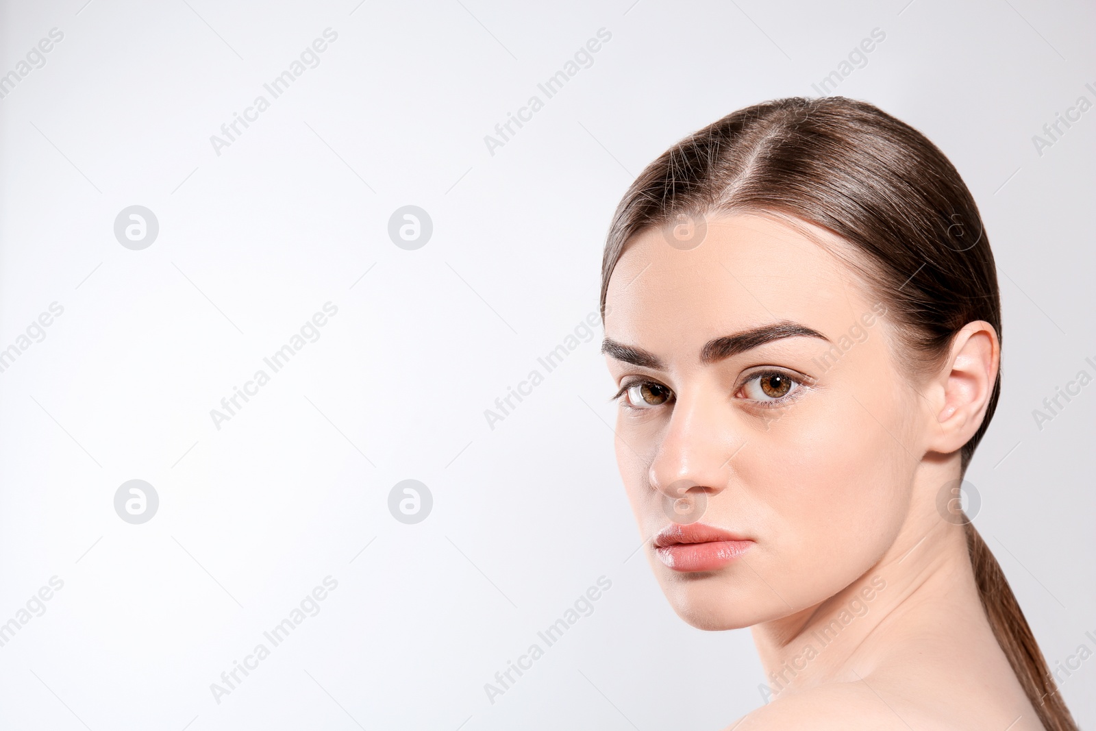 Photo of Beautiful woman with perfect eyebrows on light background