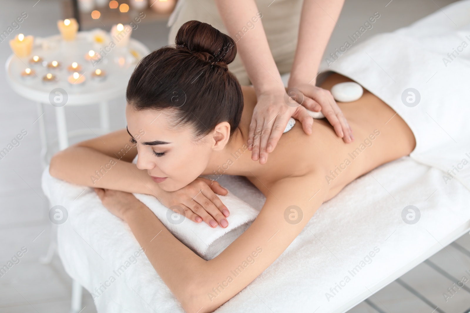 Photo of Young woman receiving massage in spa salon