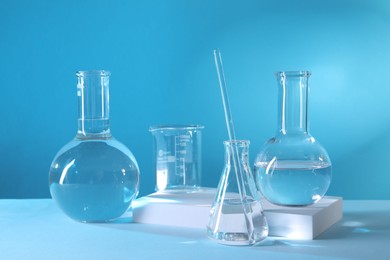 Photo of Laboratory analysis. Different glassware on table against light blue background