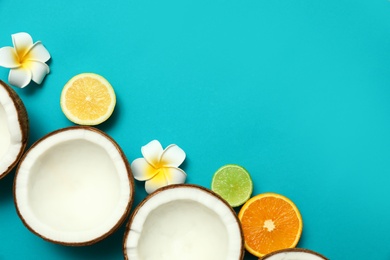 Flat lay composition with fresh coconut halves on blue background. Space for text