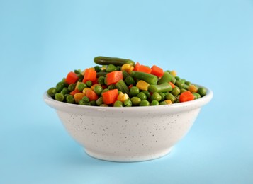 Photo of Mix of fresh vegetables in bowl on light blue background