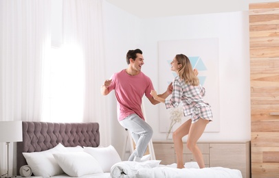 Photo of Beautiful young couple dancing in bedroom at home