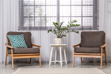 Photo of Room interior with modern armchairs and table near window