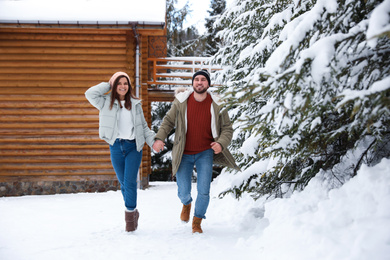 Lovely couple spending time together on snowy day. Winter vacation