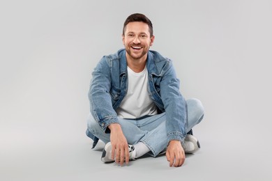 Photo of Happy man sitting on light gray background