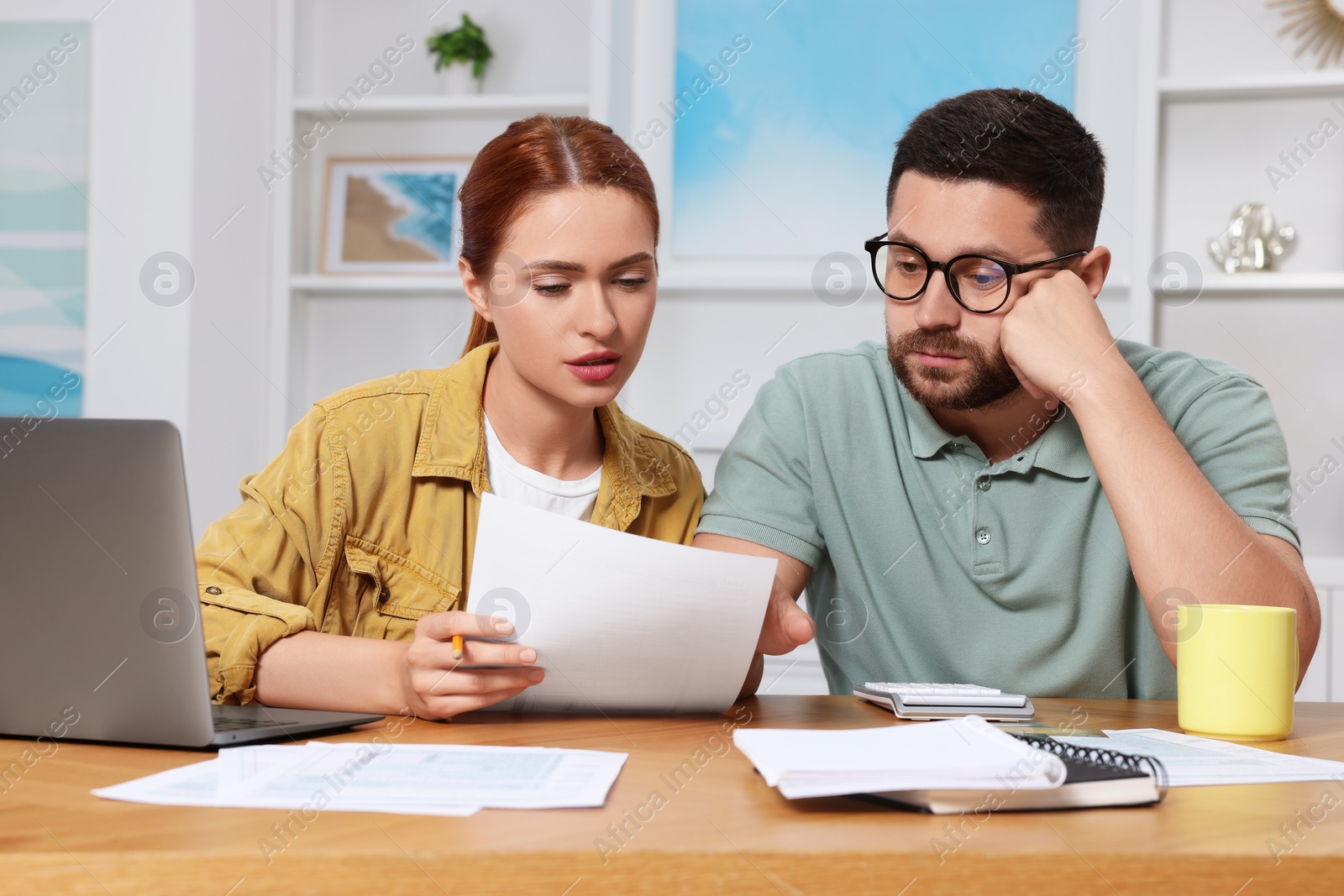 Photo of Couple doing taxes at table in room