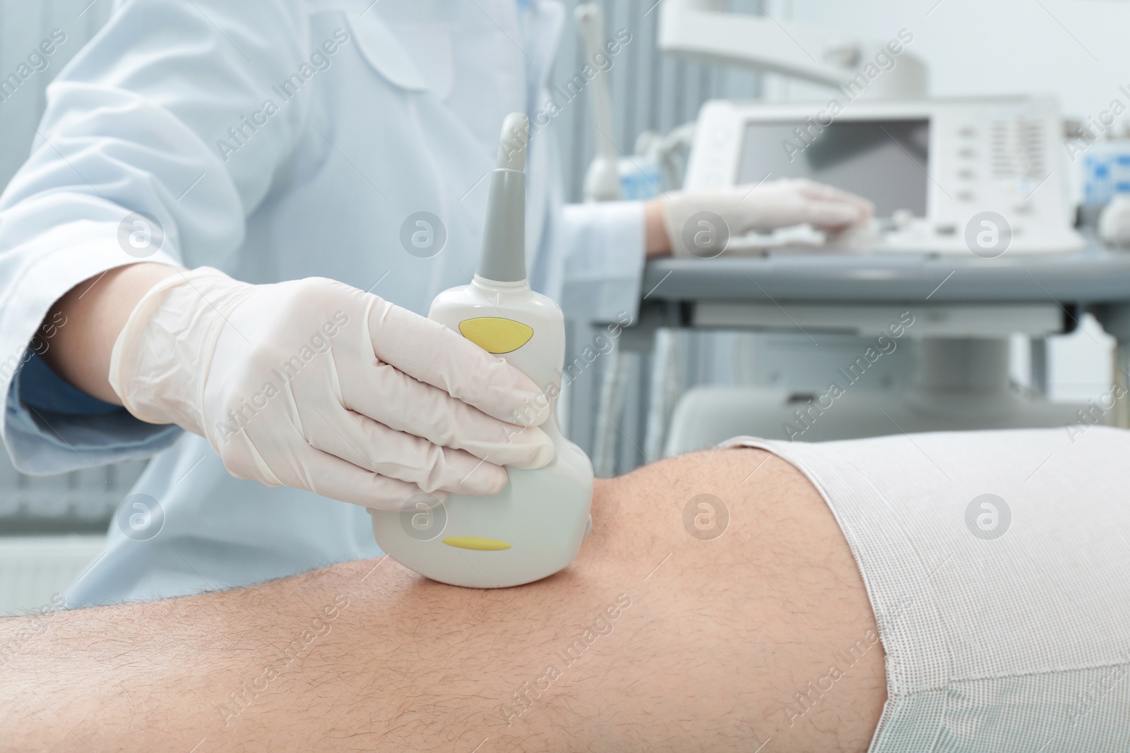 Photo of Doctor conducting ultrasound examination of patient's knee in clinic