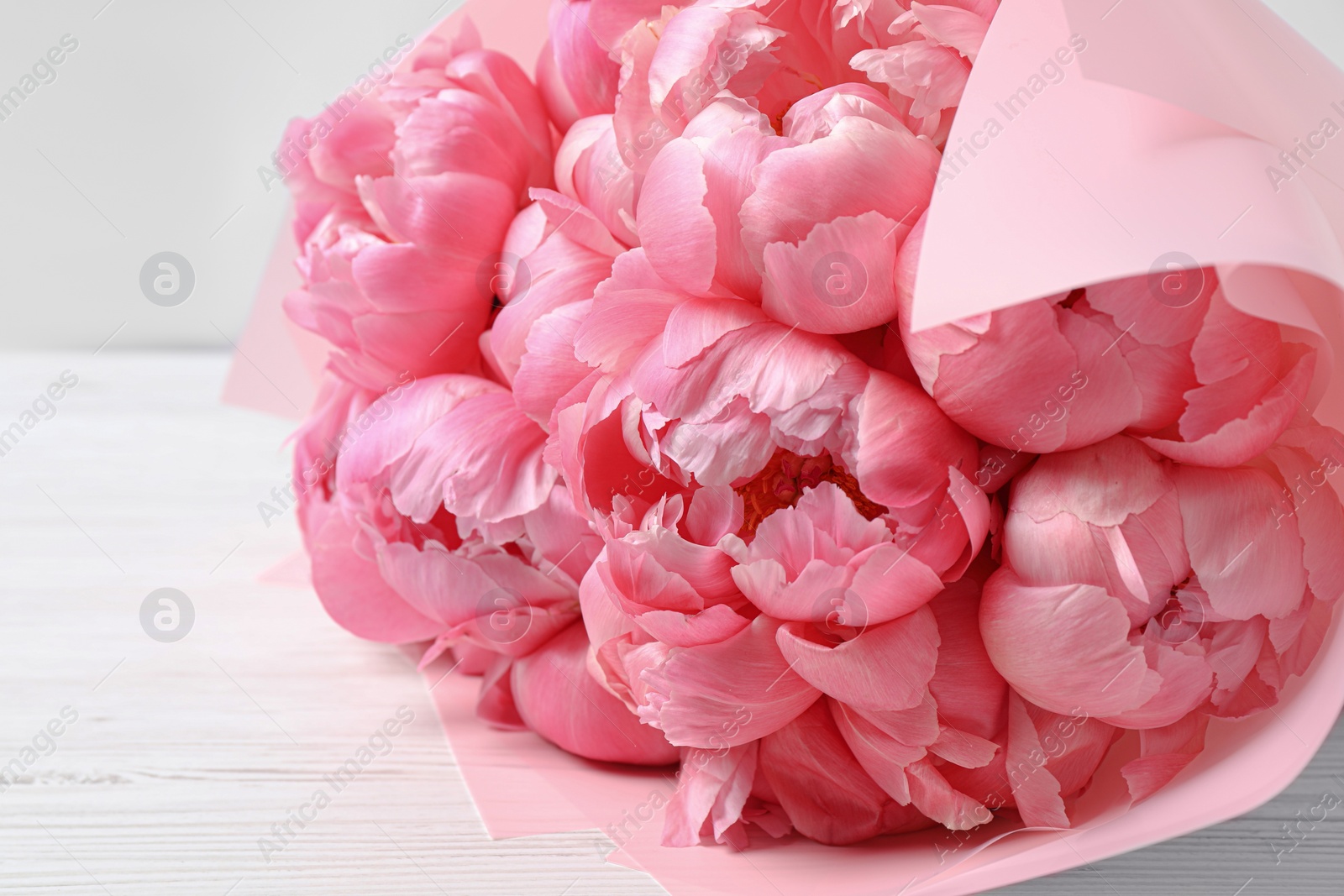 Photo of Bouquet of beautiful pink peonies on white wooden table, closeup