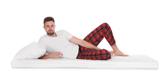 Man with pillow lying on soft mattress against white background