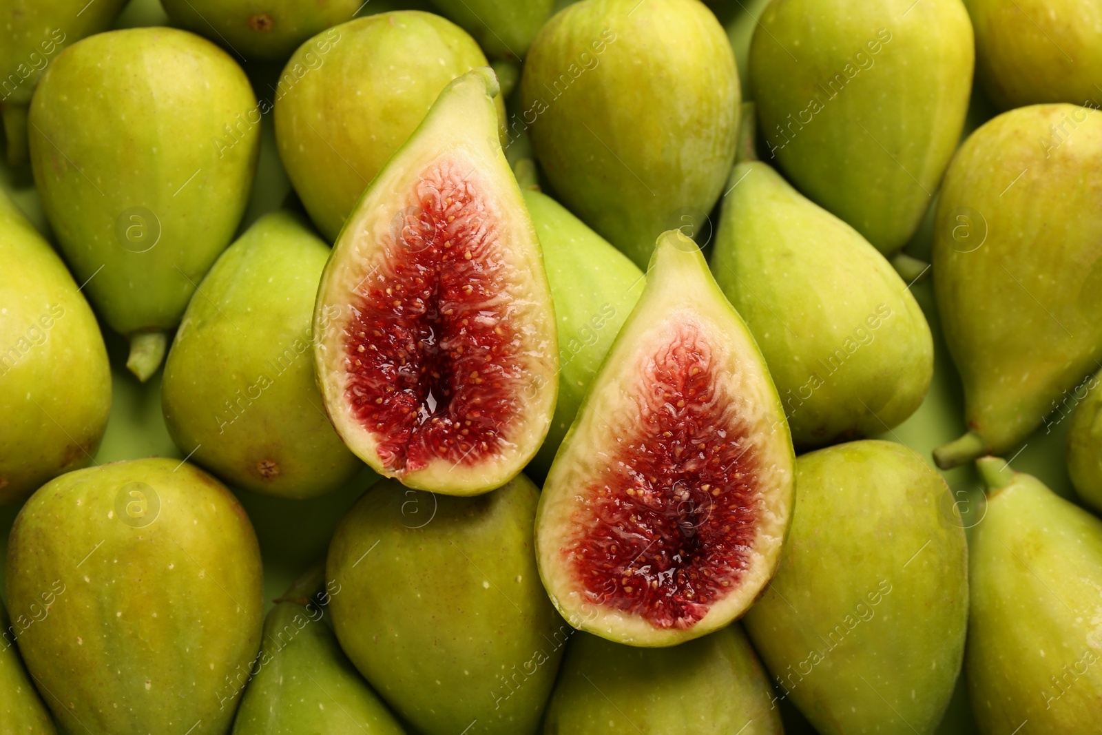 Photo of Halves of green fig on fresh fruits, top view