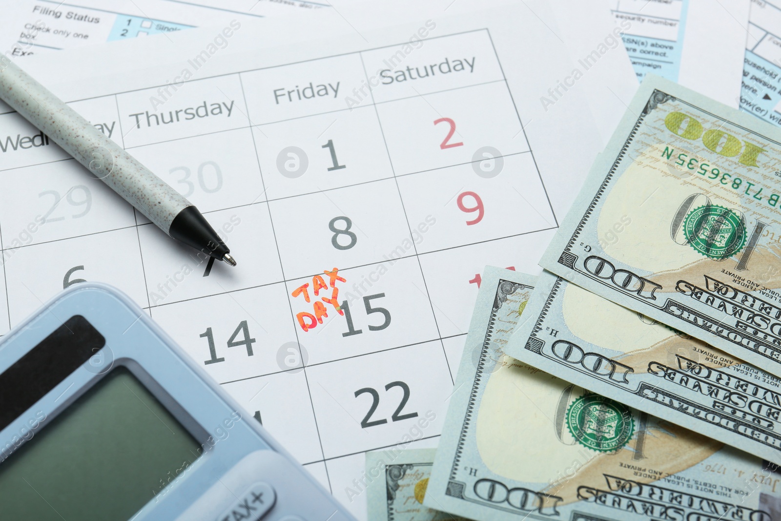 Photo of Calendar with date reminder about tax day, documents, money, pen and calculator, closeup