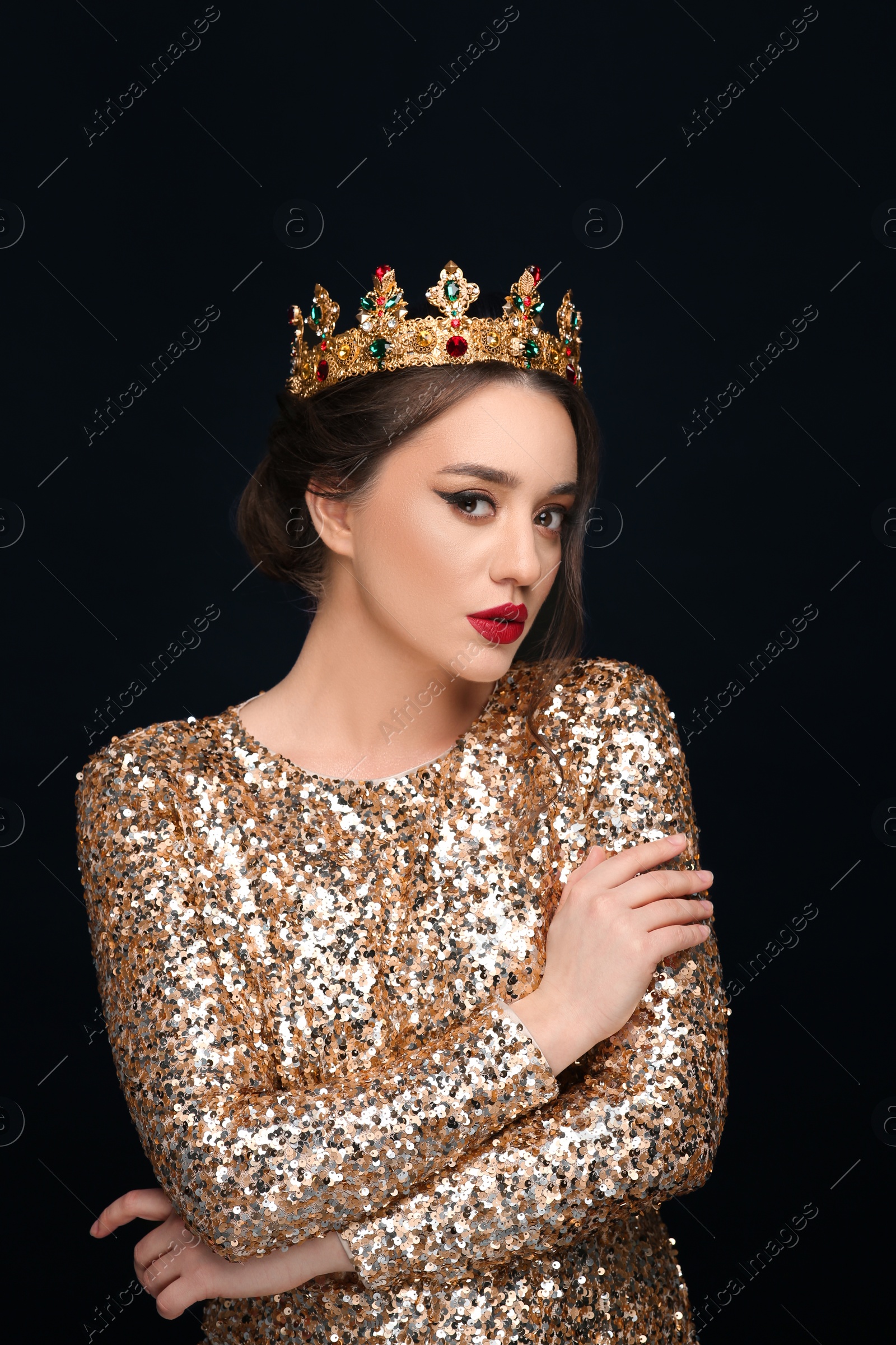 Photo of Beautiful young woman wearing luxurious crown on black background