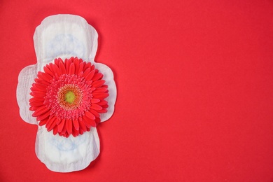 Photo of Flat lay composition with menstrual pad and flower on color background. Gynecological checkup