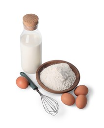 Photo of Whisk, raw eggs, flour and bottle of milk isolated on white