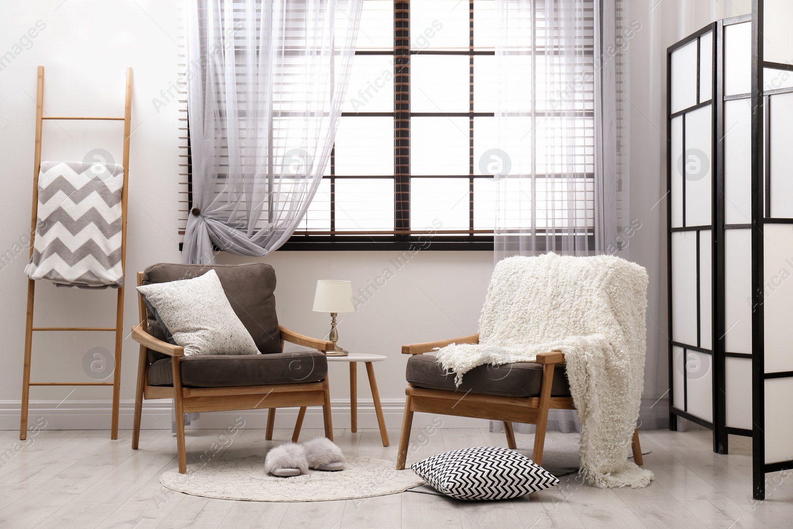 Photo of Cozy interior with armchairs, pillows and plaid near window