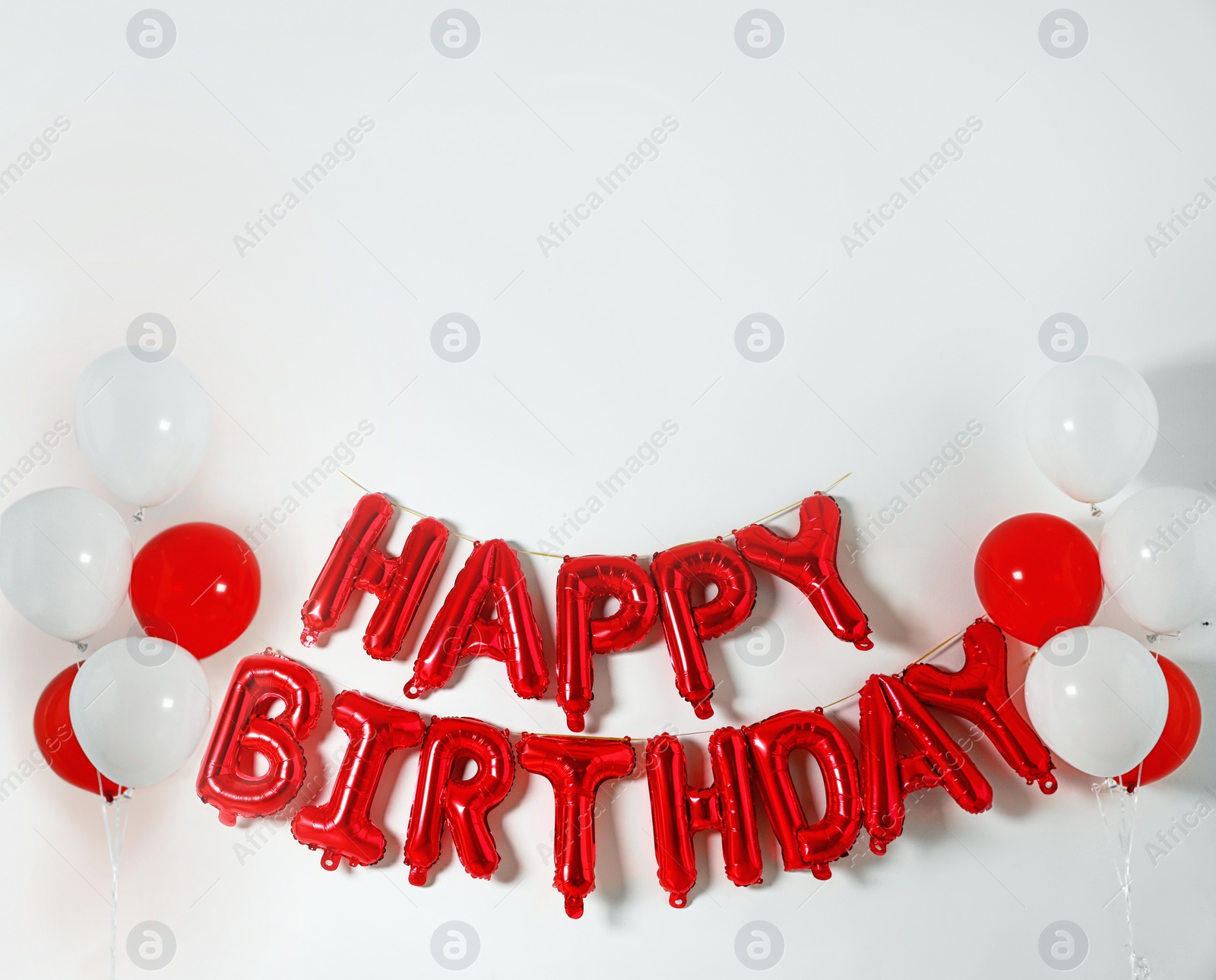 Photo of Phrase HAPPY BIRTHDAY made of color balloon letters on white background. Space for text