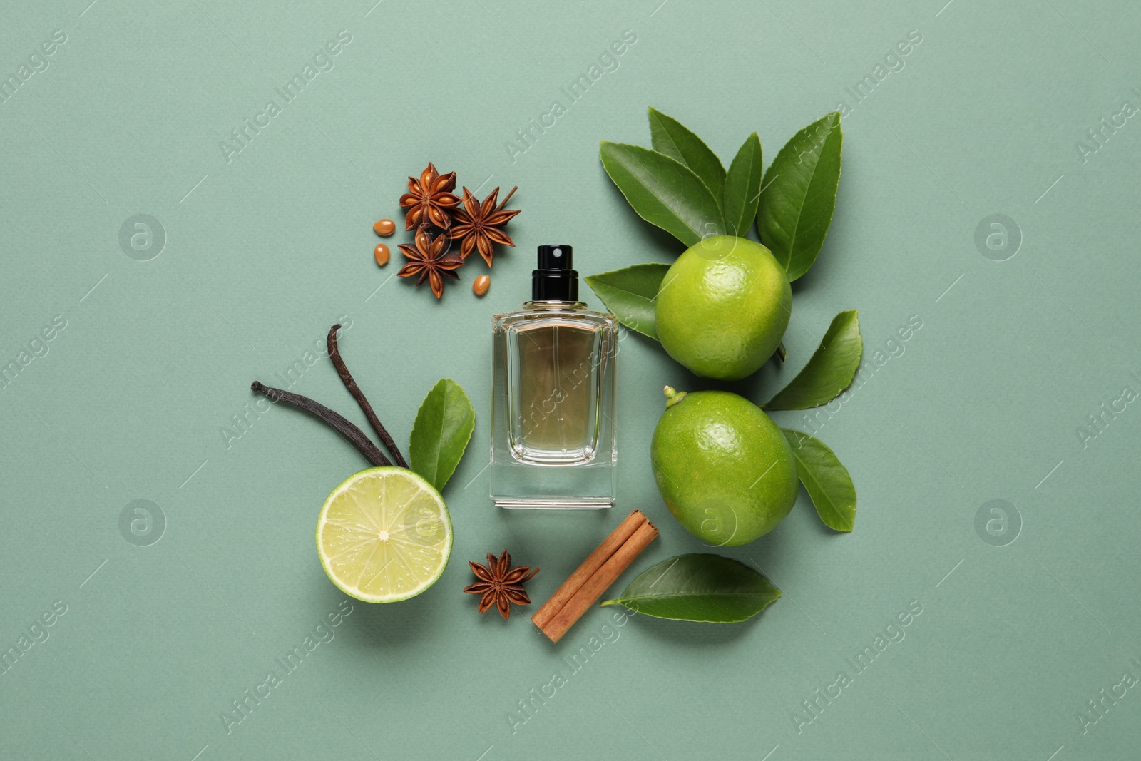 Photo of Flat lay composition with bottleperfume and fresh citrus fruits on pale green background