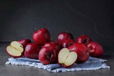 Fresh ripe red apples on grey table