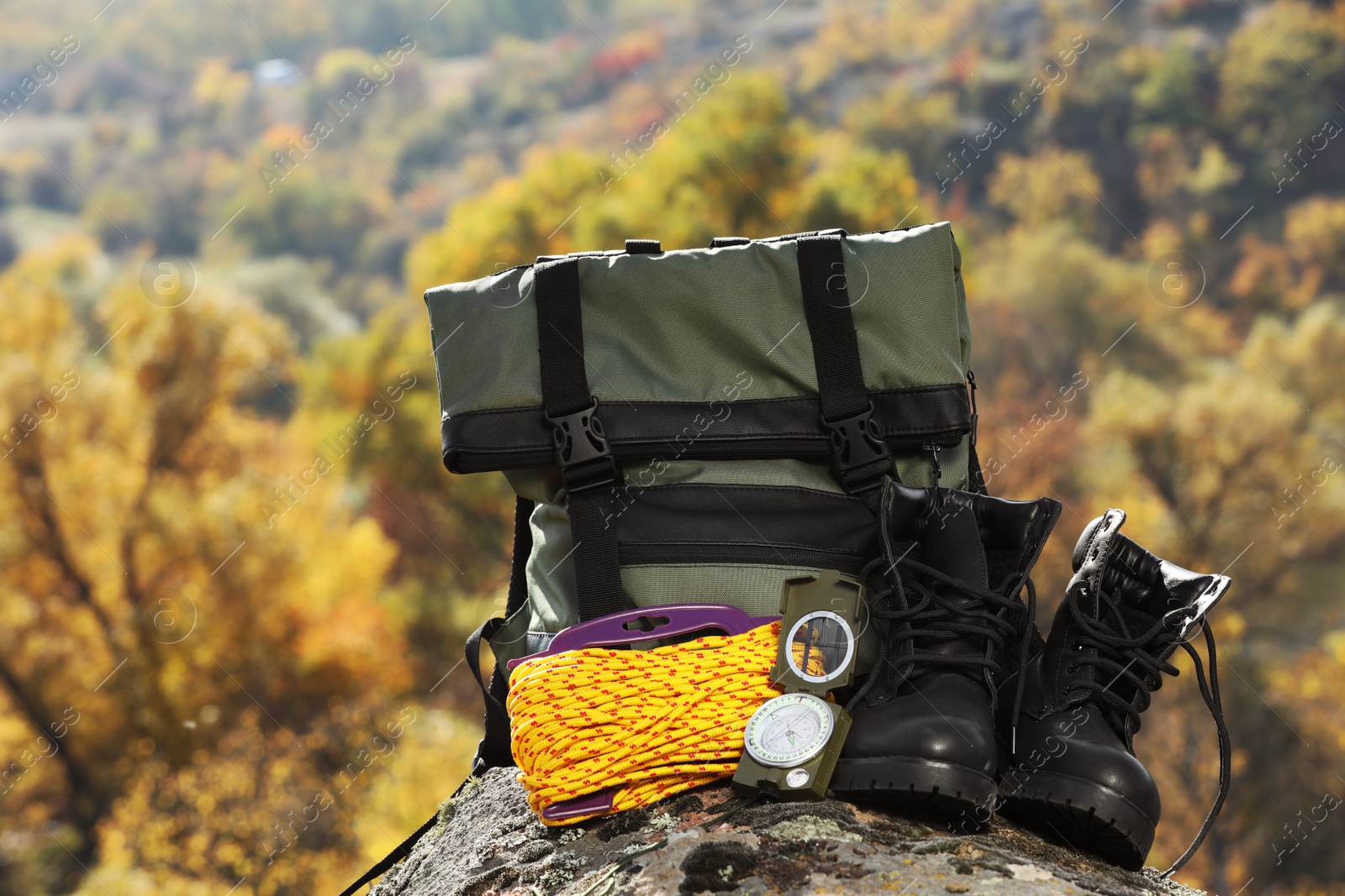 Photo of Set of camping equipment on rock outdoors. Space for text