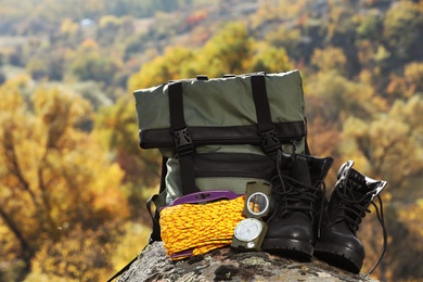 Set of camping equipment on rock outdoors. Space for text