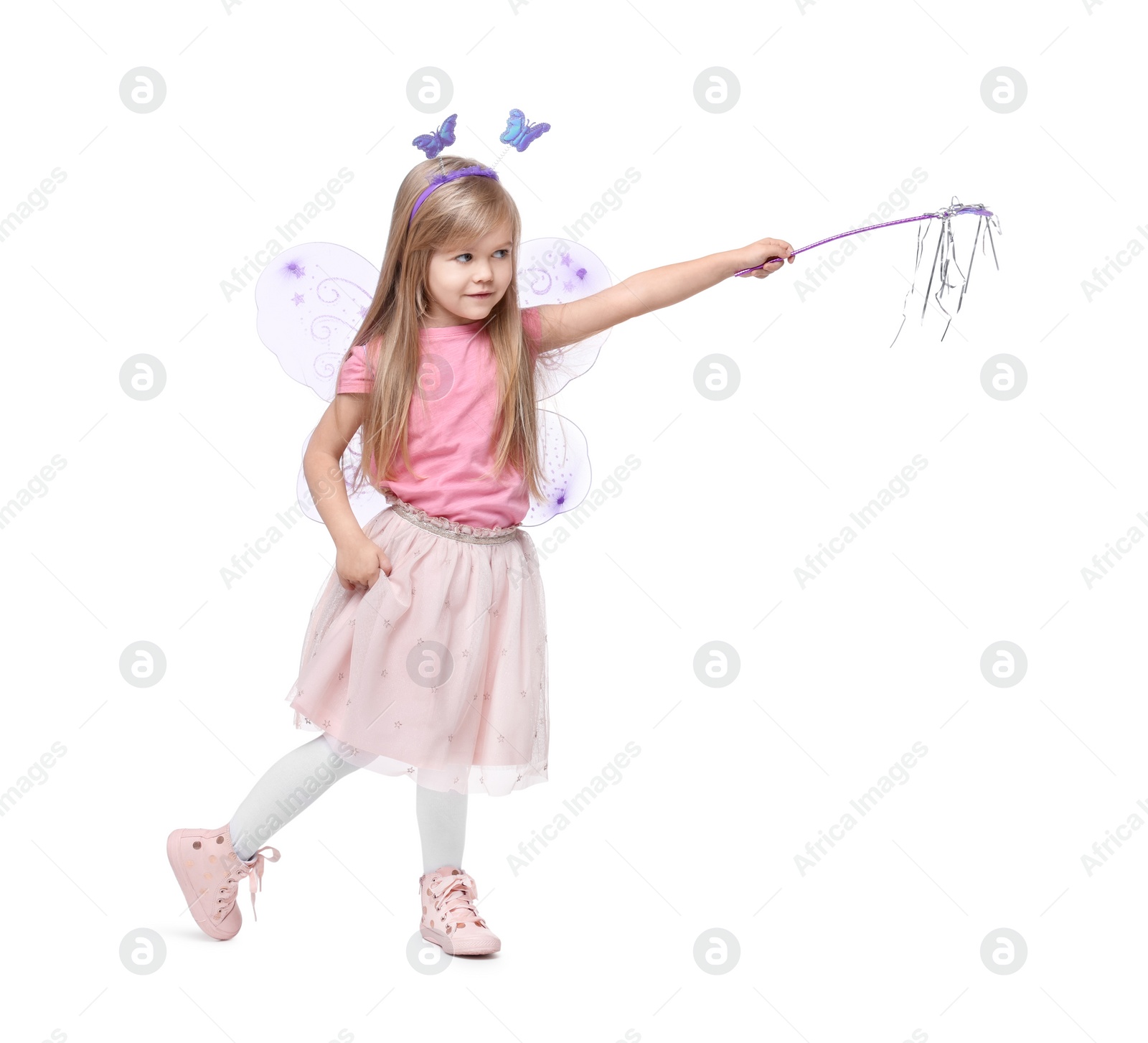 Photo of Cute little girl in fairy costume with violet wings and magic wand on white background