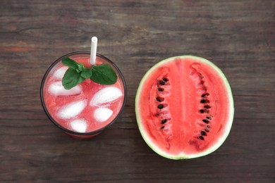 Photo of Glass of delicious watermelon drink with mint, ice cubes and fresh cut fruit on wooden table, flat lay