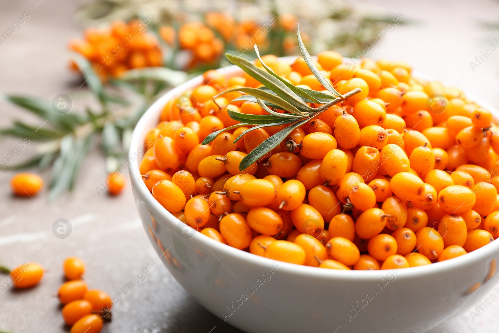 Photo of Ripe sea buckthorn berries on marble table, closeup