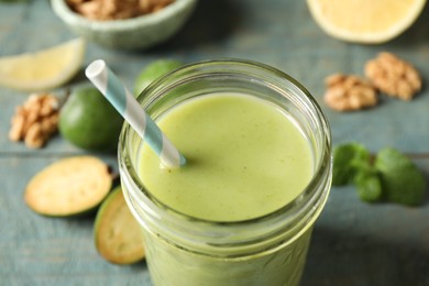 Fresh feijoa smoothie in glass on table, closeup view