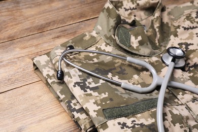 Photo of Stethoscope and military uniform on wooden table