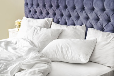 Comfortable bed with white linen at home