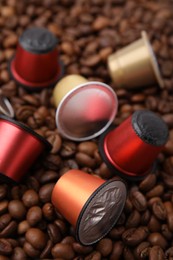 Many different coffee capsules on beans, closeup