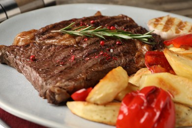 Photo of Delicious grilled beef steak and vegetables on plate, closeup