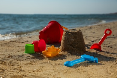 Set of plastic beach toys on sand near sea. Outdoor play