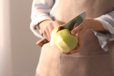 Photo of Woman peeling ripe apple, closeup