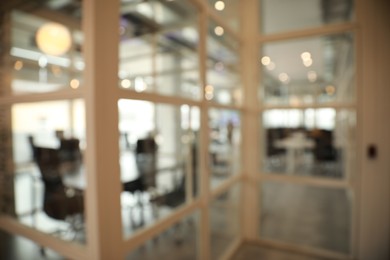 Photo of Blurred view of empty conference room and glass door in office