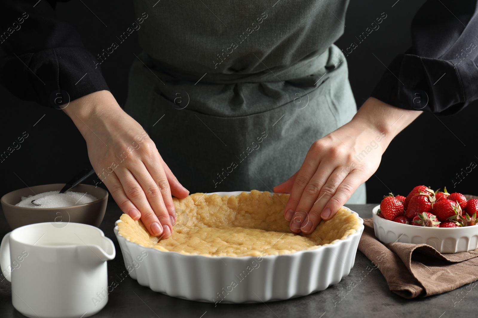 Photo of Shortcrust pastry. Woman making pie at grey table, closeup