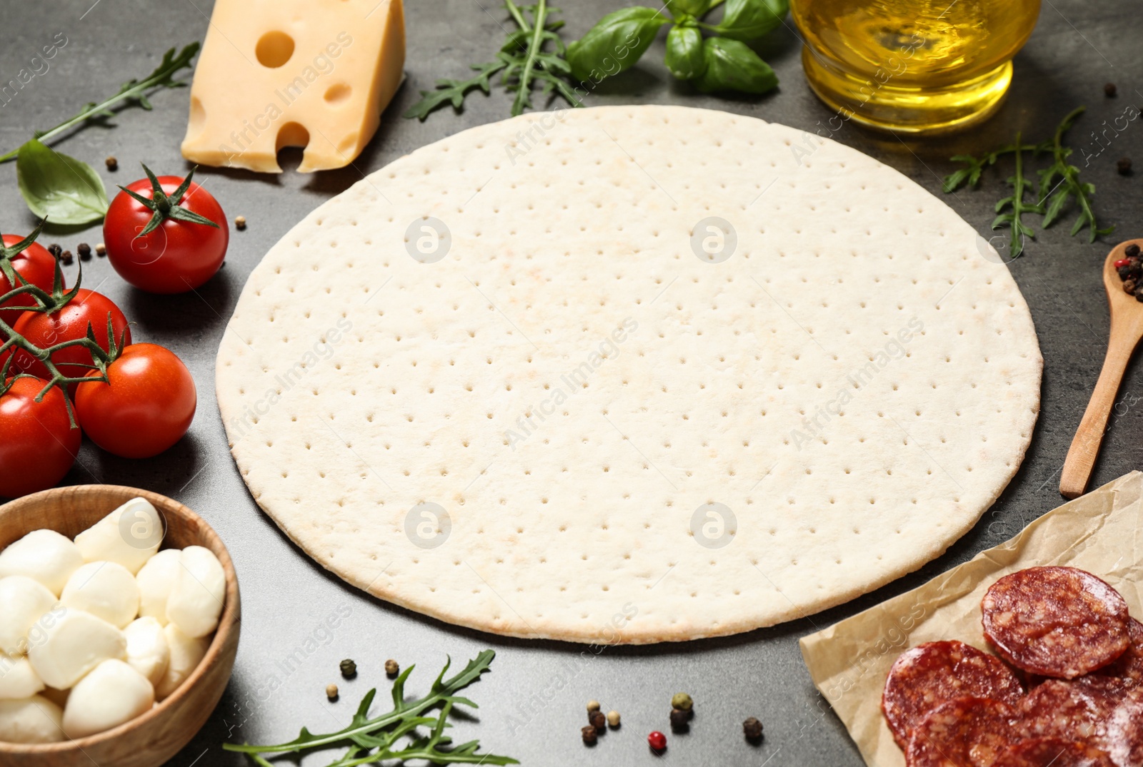 Photo of Dough and fresh ingredients for pepperoni pizza on grey table