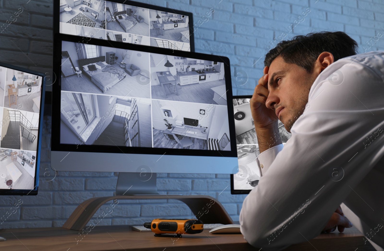 Photo of Male security guard monitoring cameras at workplace