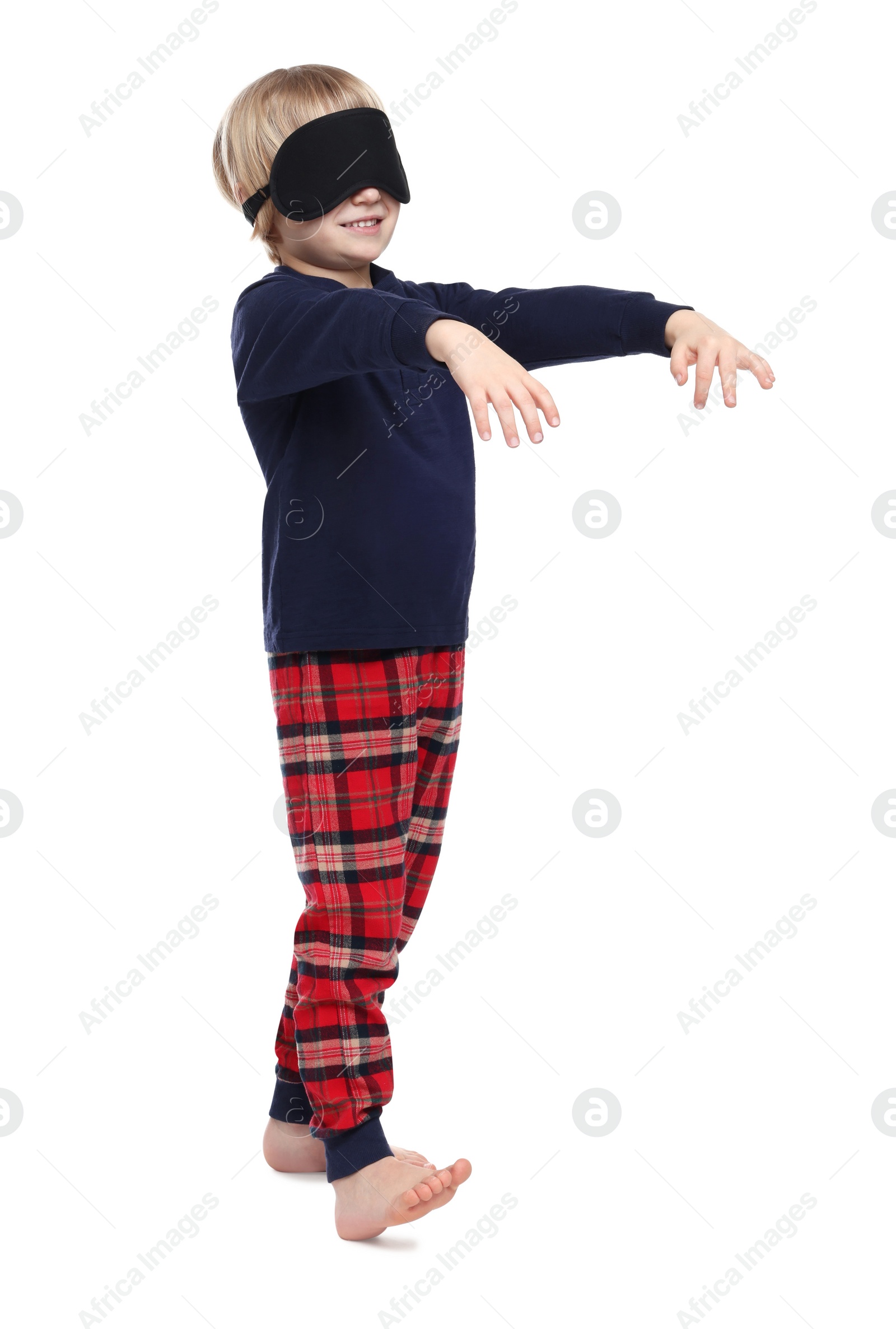 Photo of Boy in pajamas and sleep mask sleepwalking on white background