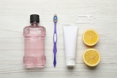 Photo of Flat lay composition with mouthwash and other oral hygiene products on white wooden table