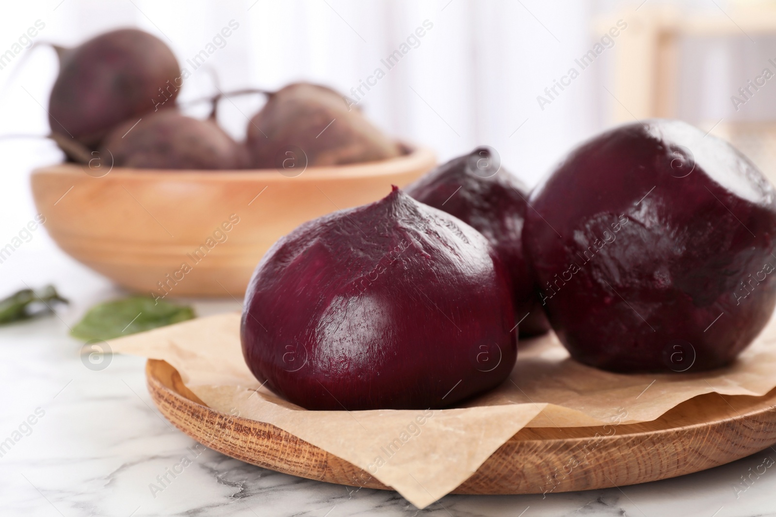 Photo of Plate with ripe peeled beets on table